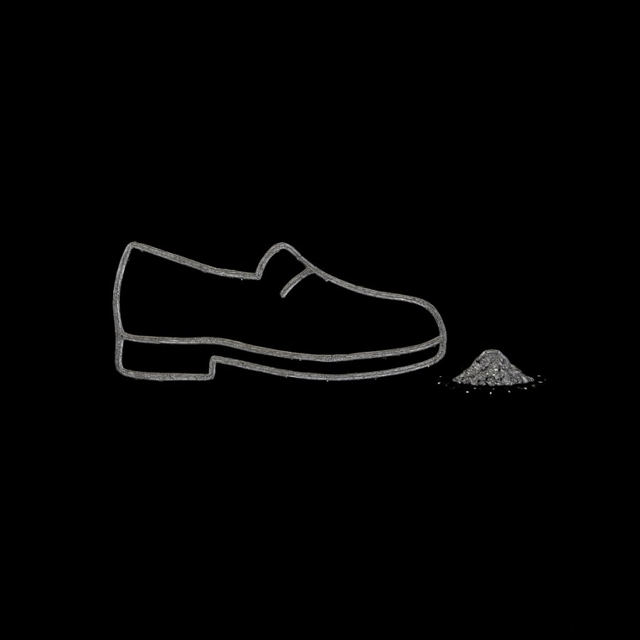 Zapato dibujado con trazos blancos sobre fondo negro junto a un pequeño montón de arena, estilo minimalista Umbral Cero