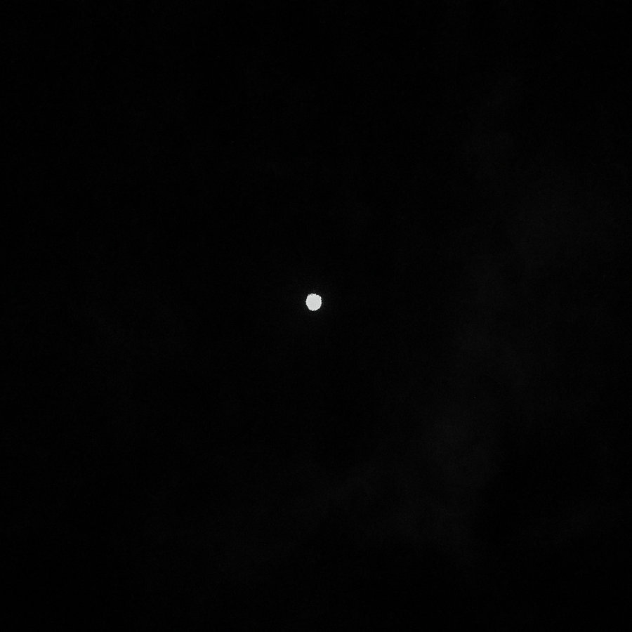 Punto de luz blanca flotando en la oscuridad, imagen atmosférica del micro-relato Lo Que No Parpadea en Umbral Cero.